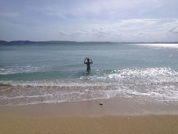 Man standing on beach against sky