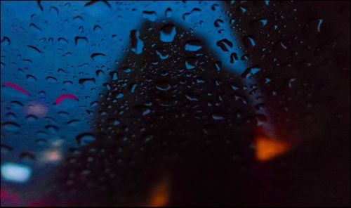 Close-up of water drops against blue sky