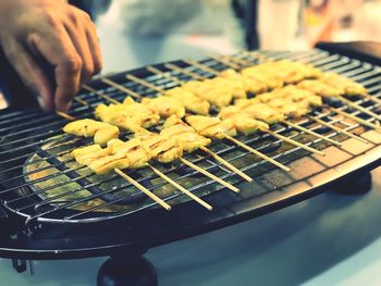 Close-up of person preparing food on barbecue grill