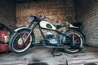 Bicycle parked against brick wall