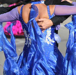 Midsection of woman holding blue umbrella