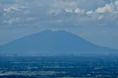 Aerial view of townscape and mountains against sky