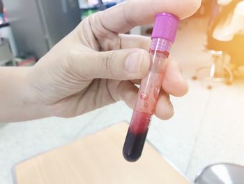 Cropped hand of scientist holding test tube with liquid in laboratory