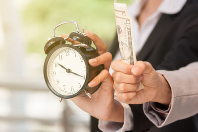 Close-up of hand holding clock