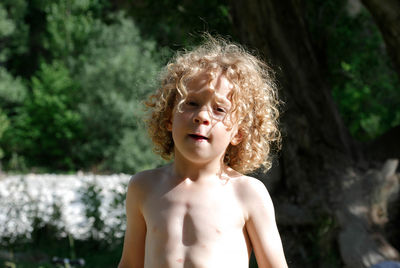 Portrait of shirtless boy standing outdoors