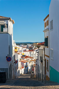 Buildings in city against clear blue sky