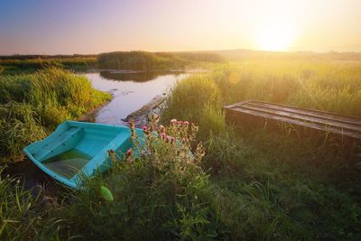 Scenic view of land by lake against sky