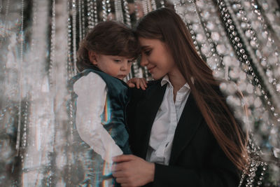 Portrait of woman with daughter against blurred background