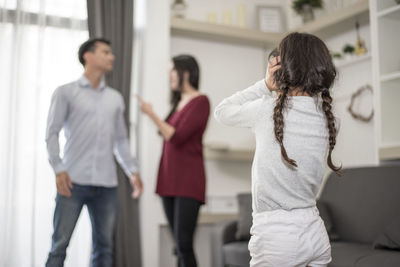 Daughter looking at parents fighting in house