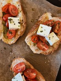 High angle view of sliced bread italian style with tomatoes, feta and basil pesto