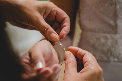 Close-up of hand dressing bride