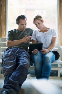 Couple using tablet computer in house being renovated