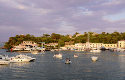 Boats in sea against buildings in city