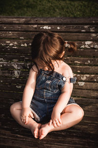 Cute girl sitting on wood