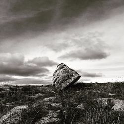 Rocks on field against sky