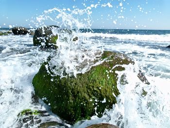 Water splashing in sea against sky