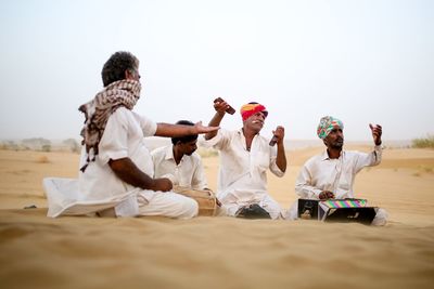 Group of people sitting on sand