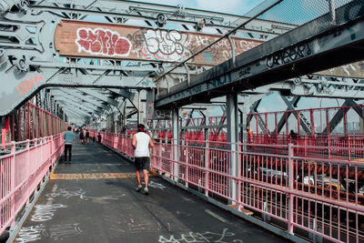 Rear view of woman walking on footbridge