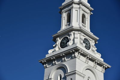 Low angle view of bell tower against blue sky