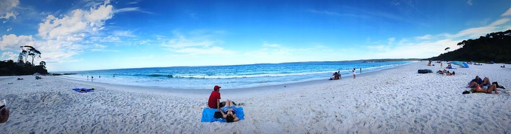 Panoramic view of people on beach against sky