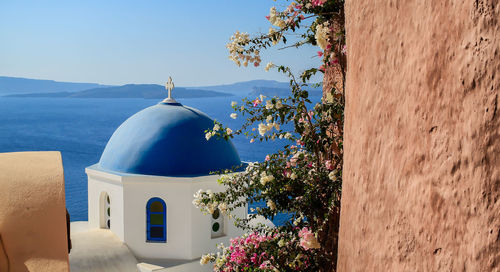 Built structure by calm sea with mountain range in background
