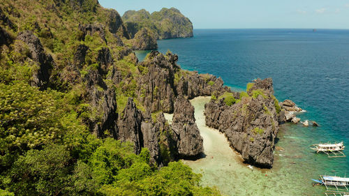 Aerial view of tropical lagoon with sandy beach surrounded by cliffs. el nido, philippines, palawan.