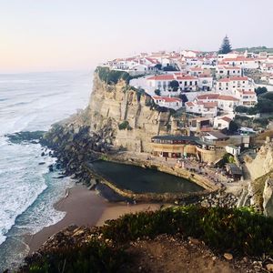 High angle view of buildings by sea against clear sky