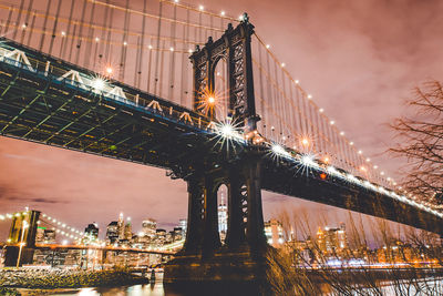 Low angle view of bridge over river at night