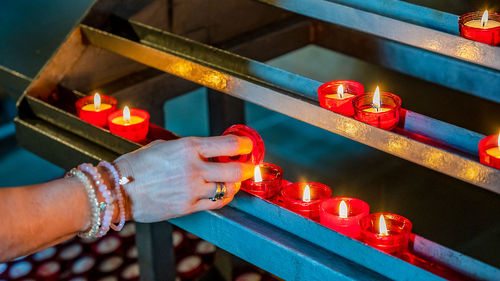 Midsection of man holding burning candles