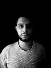 Portrait of young man against black background