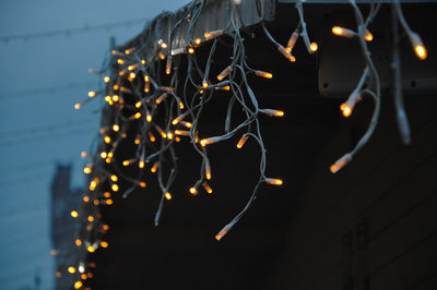 Close-up of illuminated lighting equipment hanging at night