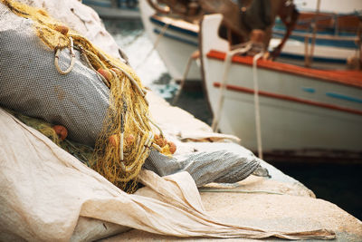 Close-up of fishing net with moored boat at beach