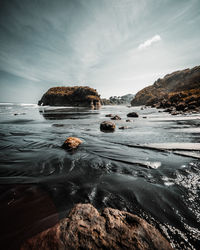 Scenic view of rocks in sea against sky