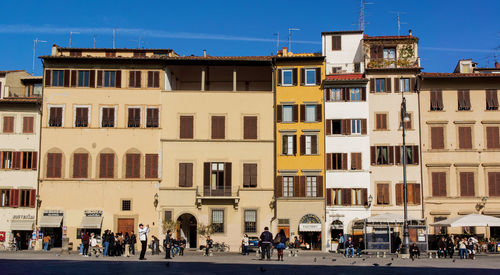 People on street against buildings in city