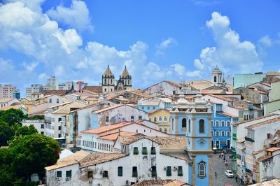 Buildings in city against cloudy sky