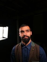 Mid adult man standing against black background