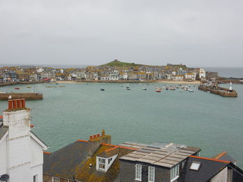 High angle view of townscape by sea against sky