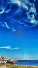 Airplane flying over sea against sky