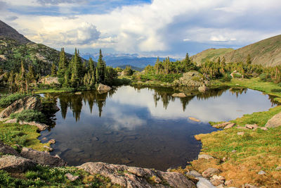 Scenic view of lake by trees against sky