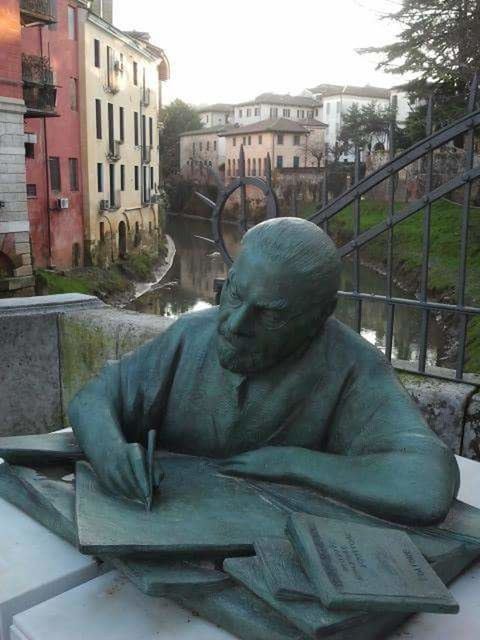 CLOSE-UP OF STATUE AGAINST BUILDINGS