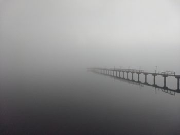 Scenic view of lake against sky during foggy weather