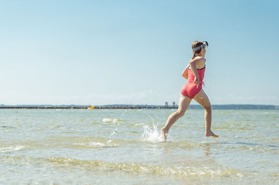 Full length of woman on beach against sky