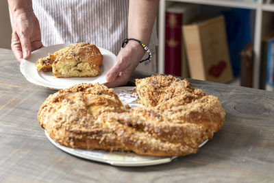 Midsection of man holding bread on table