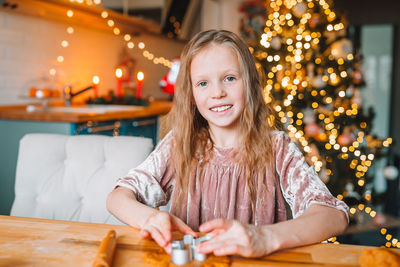 Portrait of smiling girl sitting on table