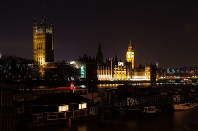 Illuminated buildings in city against sky at night