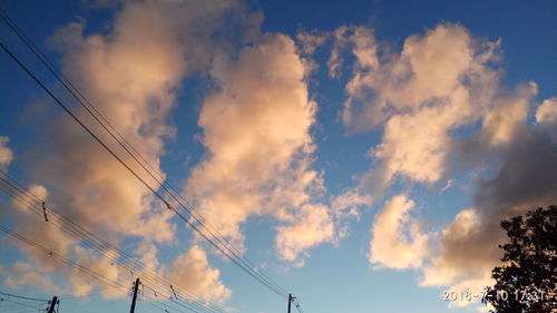 Low angle view of silhouette electricity pylon against sky