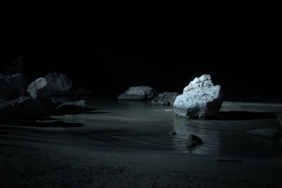 Rocks on shore at night