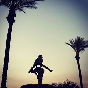 Low angle view of statues against sky during sunset