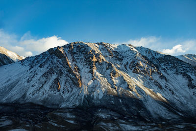 Scenic view of snowcapped mountains against blue sky