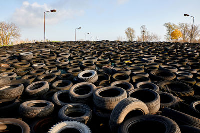 Stack of hay bales on field against sky